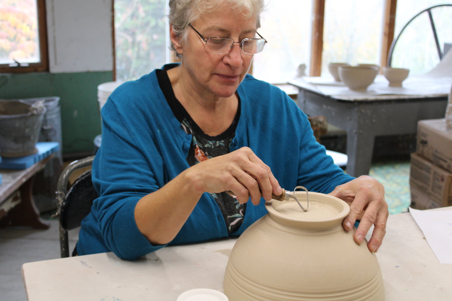 Ellany Gable demonstrates the shaping of the bottom of a pot.